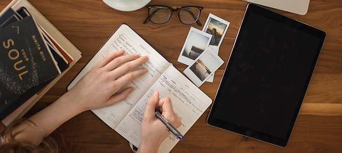 WFH Article Image 02 person sitting at a desk writing in a journal